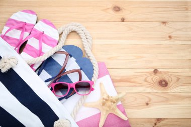 Flip flop ve ahşap masa üzerinde güneş gözlüğü ile yaz çanta