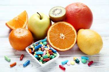 Olgunlaşmış meyve ve ahşap masa ıslak zeminde renkli hap