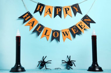 Mavi zemin üzerine mumlar, örümcekleriyle Halloween süslemeleri