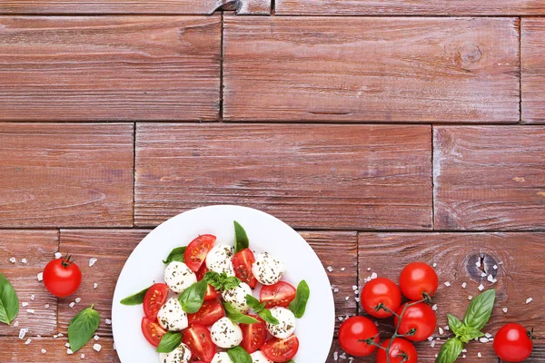 Mozzarella Pomodori Foglie Basilico Piatto Tavolo Legno Marrone — Foto Stock