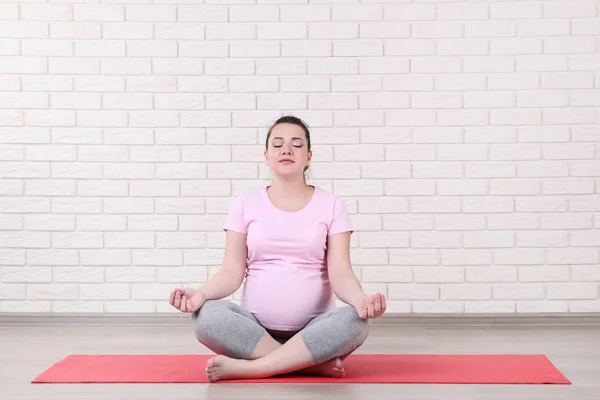 Unga Gravid Kvinna Gör Övningar Tegel Vägg Bakgrund — Stockfoto