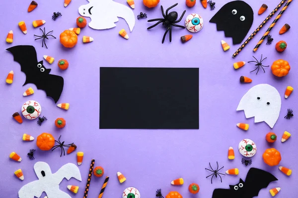 紫色の背景に装飾とハロウィンのお菓子 — ストック写真