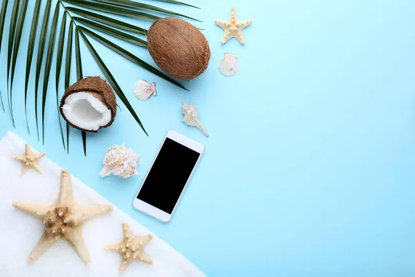 蓝色背景上的椰子配贝壳和智能手机 — 图库照片