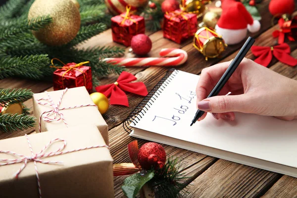 Female Hand Writing List Notepad Christmas Decoration Wooden Table — Stock Photo, Image