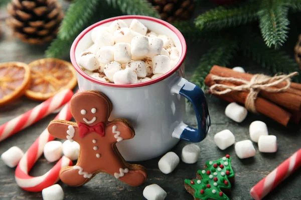 Cappuccino with marshmallow in mug with gingerbread cookies on wooden table