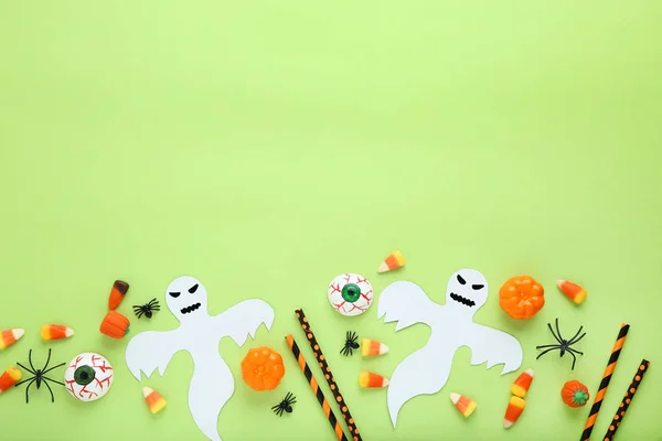 緑の背景の紙の装飾とハロウィンのお菓子 — ストック写真