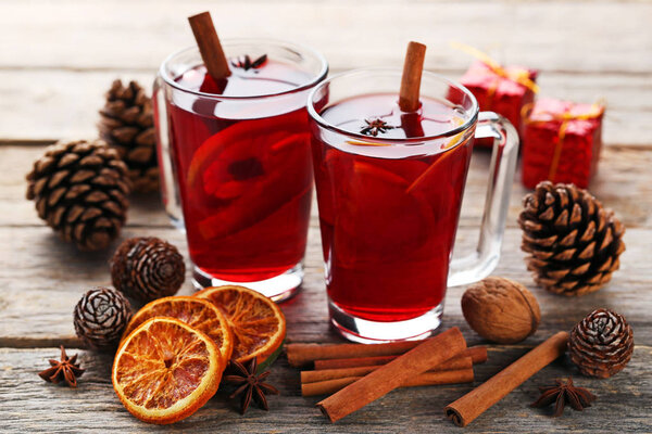 Mulled wine in glasses with spices on wooden table