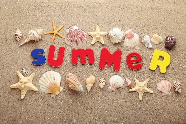 砂浜で貝殻を色付き文字で碑文夏 — ストック写真
