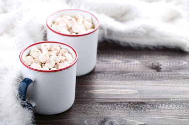 Kapuçino kupalar ve eşarp ahşap masa üzerinde marshmallow ile