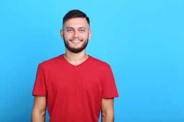 Mavi arka plan üzerinde kırmızı t-shirt genç adam