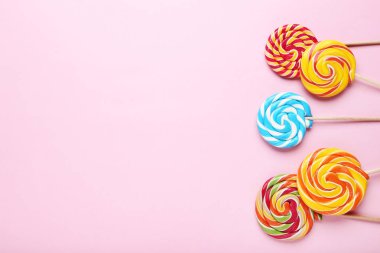 Pembe bir arka plan üzerinde renkli lolipop