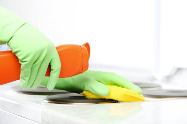 Soba ellerinde eldiven sünger ve deterjan temizlik şişe ile elektrik