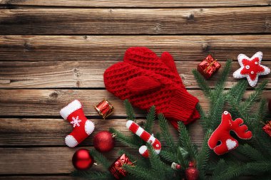 Köknar-ağaç dalları ve Noel dekorasyonları ahşap masa üzerinde kırmızı örme eldiven