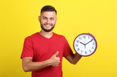 Delikanlı ile sarı zemin üzerine yuvarlak masa saati