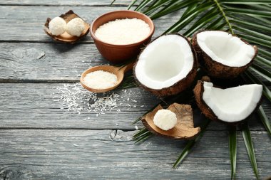 Pul kase ve palm ile olgunlaşmış hindistancevizi yapraklar üzerinde gri ahşap masa