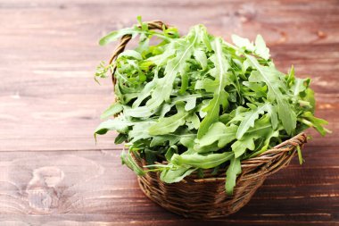 Sepette kahverengi ahşap masa üzerinde yeşil roka yaprakları