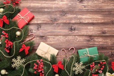 Dekorasyon ve hediye kutuları üzerinde kahverengi ahşap masa ile Noel köknar ağacı dalları