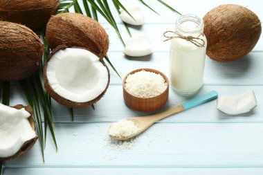 Hindistan cevizi sütü şişe pul ve palm ahşap masaya yapraklar