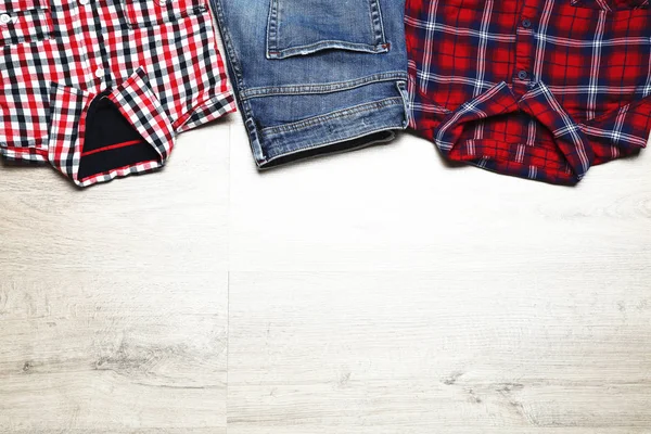 Folded shirts and jeans on wooden table