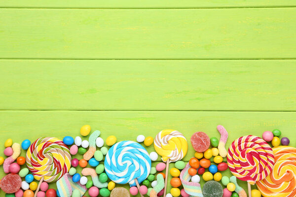 Конфеты и леденцы на зеленом деревянном столе
