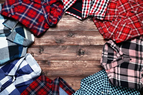 Folded shirts on brown wooden table