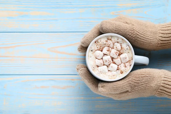 Cappuccino Mit Marshmallows Der Hand Auf Blauem Holztisch — Stockfoto