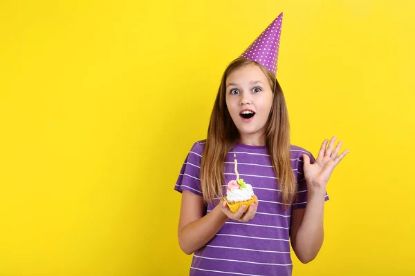 Jovencita Sombrero Cumpleaños Sosteniendo Cupcake Con Vela Sobre Fondo Amarillo — Foto de Stock