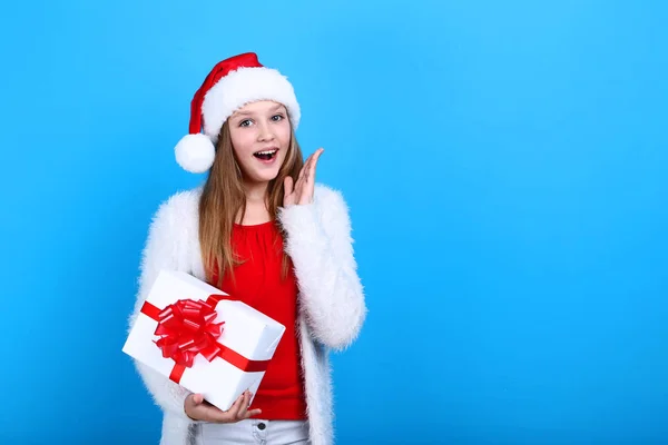 Young Girl Santa Hat Holding Gift Box Blue Background — Stock Photo, Image