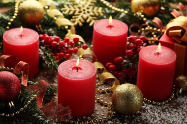 Köknar-ağaç dalları ve ahşap masa üzerinde baubles ile Noel mumlar