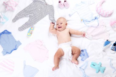 Beyaz yatakta yatarken moda giysileri ile erkek bebek