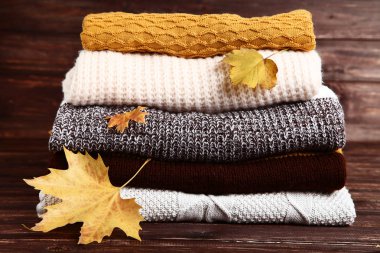 Yığın katlanmış kazak ile akçaağaç ahşap masada bırakır