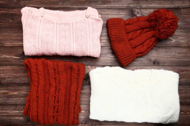 Kazak atkı ve şapka ile kahverengi ahşap masa üzerinde katlanmış