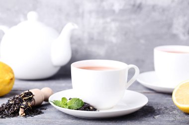 Çay nane ile yapraklar, limon ve çaydanlık gri ahşap tablo
