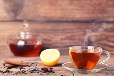 Buhar, tarçın ve limon ile çay üzerinde kahverengi ahşap masa sopa