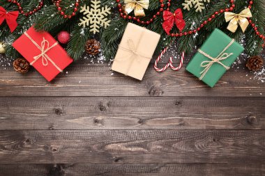 Dekorasyon ve ahşap masa üzerinde hediye kutuları ile Noel köknar ağacı dalları