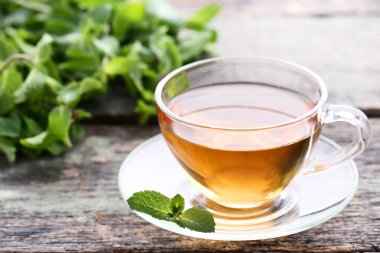 Tahta masada nane yapraklı bir fincan çay.