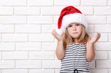 Tuğla üzerinde santa şapkalı küçük kız duvar arka plan
