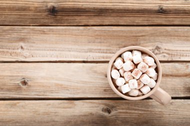 Kapuçino Kupası kahverengi ahşap masa üzerinde marshmallow ile