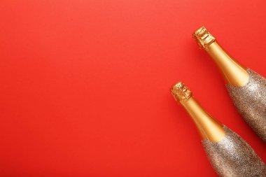 Kırmızı zemin üzerine şampanya şişeleri dekore edilmiş