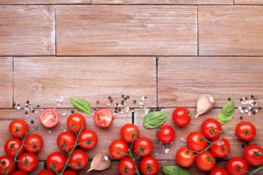 Kiraz domates fesleğen yaprağı, sarımsak ve baharat kahverengi ahşap tablo