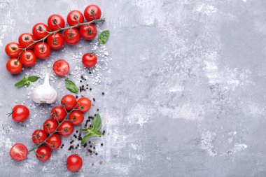 Kiraz domates fesleğen yaprağı, sarımsak ve baharat gri ahşap tablo