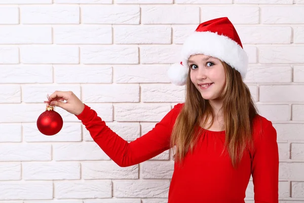 Giovane Ragazza Cappello Babbo Natale Tenendo Bagattella Natale Sfondo Muro — Foto Stock