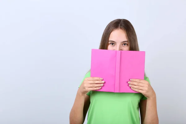 Chica Joven Con Libro Sobre Fondo Gris — Foto de Stock