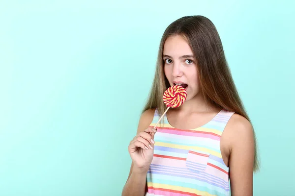 Chica Joven Comiendo Piruleta Sobre Fondo Menta —  Fotos de Stock