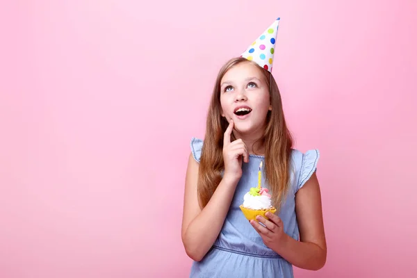 Carino Giovane Ragazza Cappello Compleanno Che Tiene Cupcake Sfondo Rosa — Foto Stock