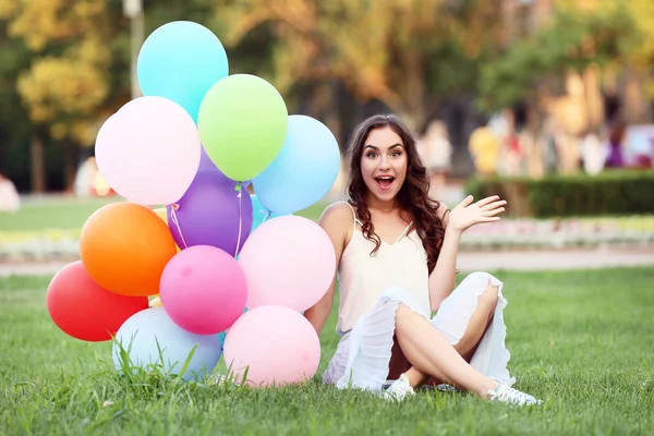 Vacker Flicka Med Färgade Ballonger Sitter Grönt Gräs — Stockfoto