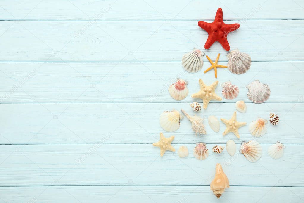 Seashells and starfishes in shape of christmas tree on wooden table