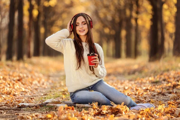 Mooie Vrouw Zitten Met Hoofdtelefoons Papier Beker Herfst Park — Stockfoto