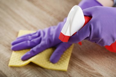 Ellerinde eldiven sünger ve deterjan temizlik mutfak masasında şişe