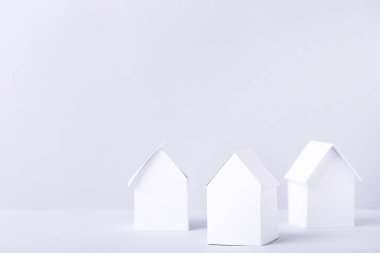 Gri arka plan üzerinde beyaz kağıt evler
